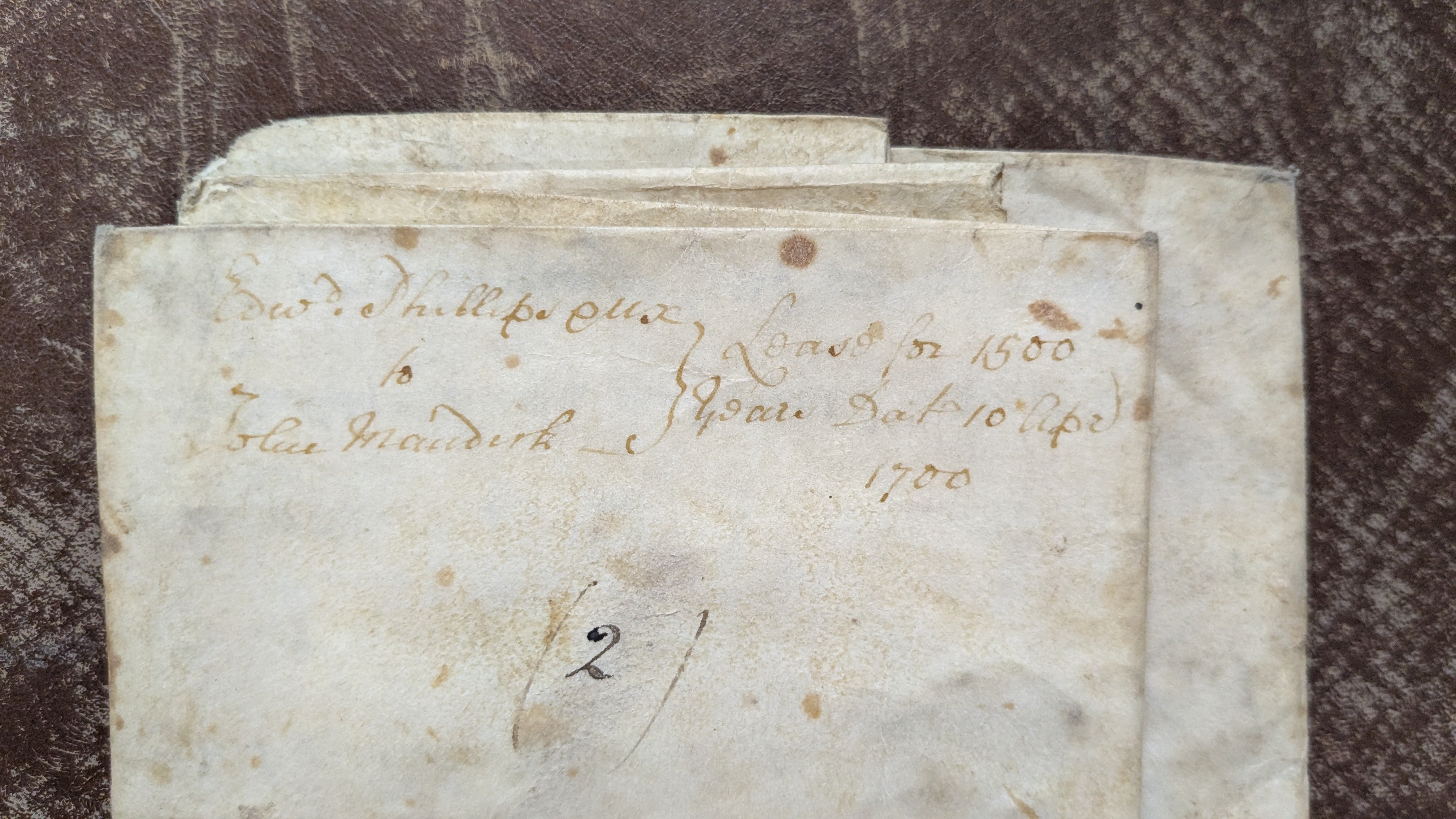 close-up shot of a record from the collection. The text is difficult to read, although the date '1700' is legible.