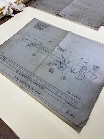 A technical drawing lies on a table, showing illustration of a Gear Change and Lever Tube