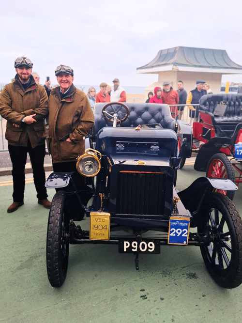Premium Members Tom and Steve, smiling next to the veteran blue Rover 8hp in the finishing paddock.