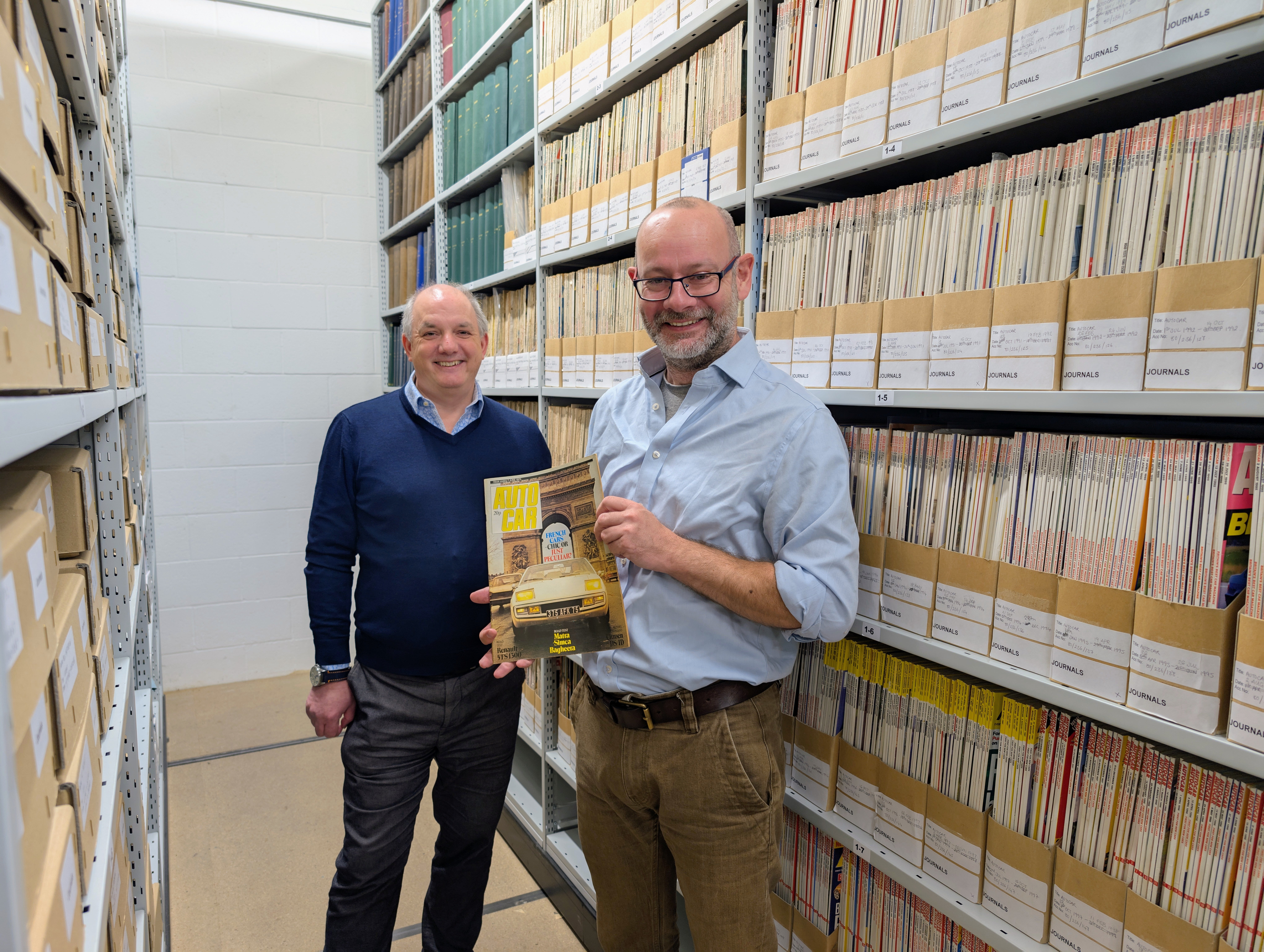 Matt Prior from Autocar holding an Autocar magazine in the Archive with the Museum's Head of Collections and Engagement, Stephen