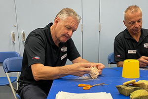 Volunteers Andrew and Malcolm work on their model clay car creations.