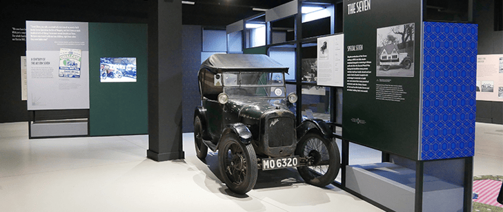 The Austin Seven that took part in Coleman's Drive on display in the exhibition, surrounded by informative graphics and a TV screen.