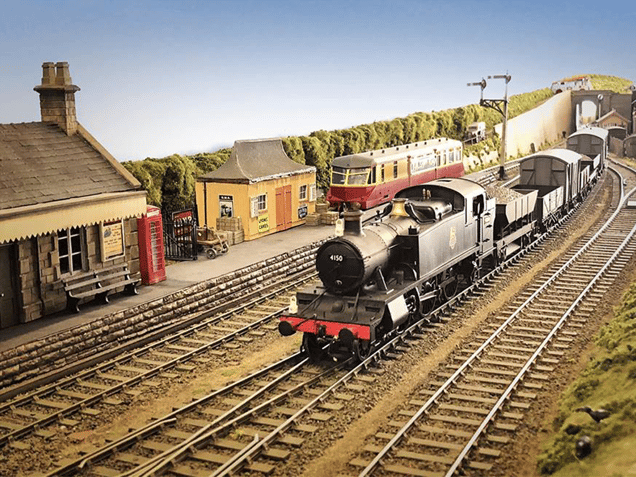 A model train on a track with a model platform next to it,