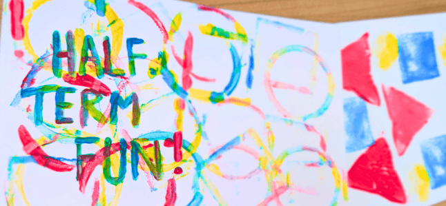 The words 'Half Term Fun' painted in different colours on a piece of paper with other colourful painted shapes and patterns